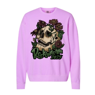 Light pink/lavender crewneck sweatshirt with a large skull graphic surrounded by blooming purple flowers and green leaves. Text reads “Rocklahoma 2025” in dark green lettering.